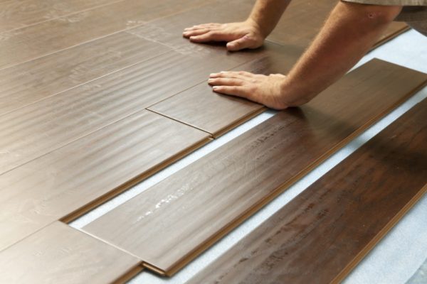 Man Installing New Laminate Wood Flooring Abstract.