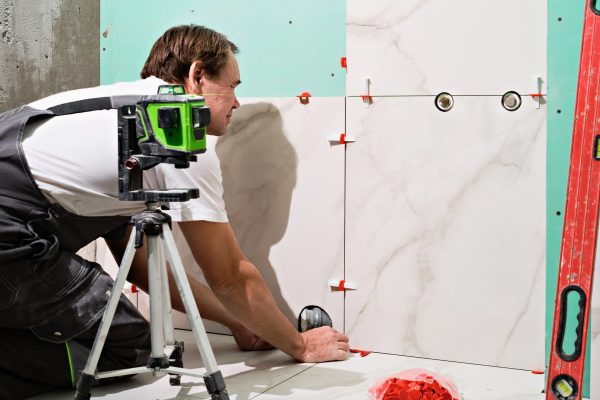 Professional master man laying ceramic tiles on floor